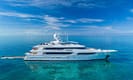 Luxury yacht in clear blue ocean under bright sky showcasing elegant design and serene marine environment.
