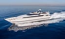 Luxury yacht cruising on the open sea with clear blue water and a sunny sky, showcasing sleek design and advanced features.