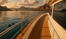 Luxury yacht sails Komodo National Park’s azure waters at sunset during Indonesia’s dry season, with gleaming teak decks, volcanic islands, tropical haze, and distant Phinisi boats. Dolphins leap near the bow, capturing the interplay of climate patterns and yachting in Indonesia.