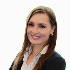 Professional woman in business attire smiling with white background.