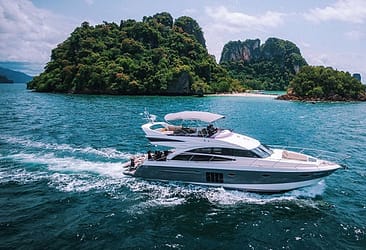 Luxury yacht cruising in turquoise waters near tropical islands with lush greenery under a clear blue sky