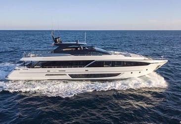 Luxury yacht cruising on open blue sea under clear sky.