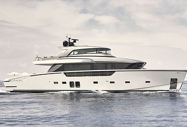 Luxury motor yacht cruising on open sea against a cloudy sky background.