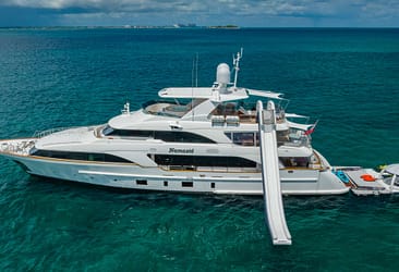 Luxury yacht named Namasté featuring a waterslide and floating platform anchored in clear blue ocean waters.