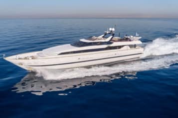Luxury yacht cruising on the open sea with clear blue water and a sunny sky, showcasing sleek design and advanced features.